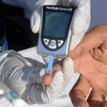 health care worker conducting a diabetes test on a patient. — AFP/File