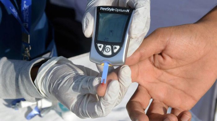 health care worker conducting a diabetes test on a patient. — AFP/File